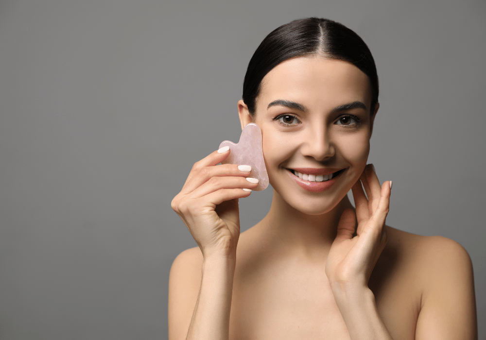 foto-di-una-ragazza-che-massaggia-il-viso-con-gua-sha-in-quarzo-rosa